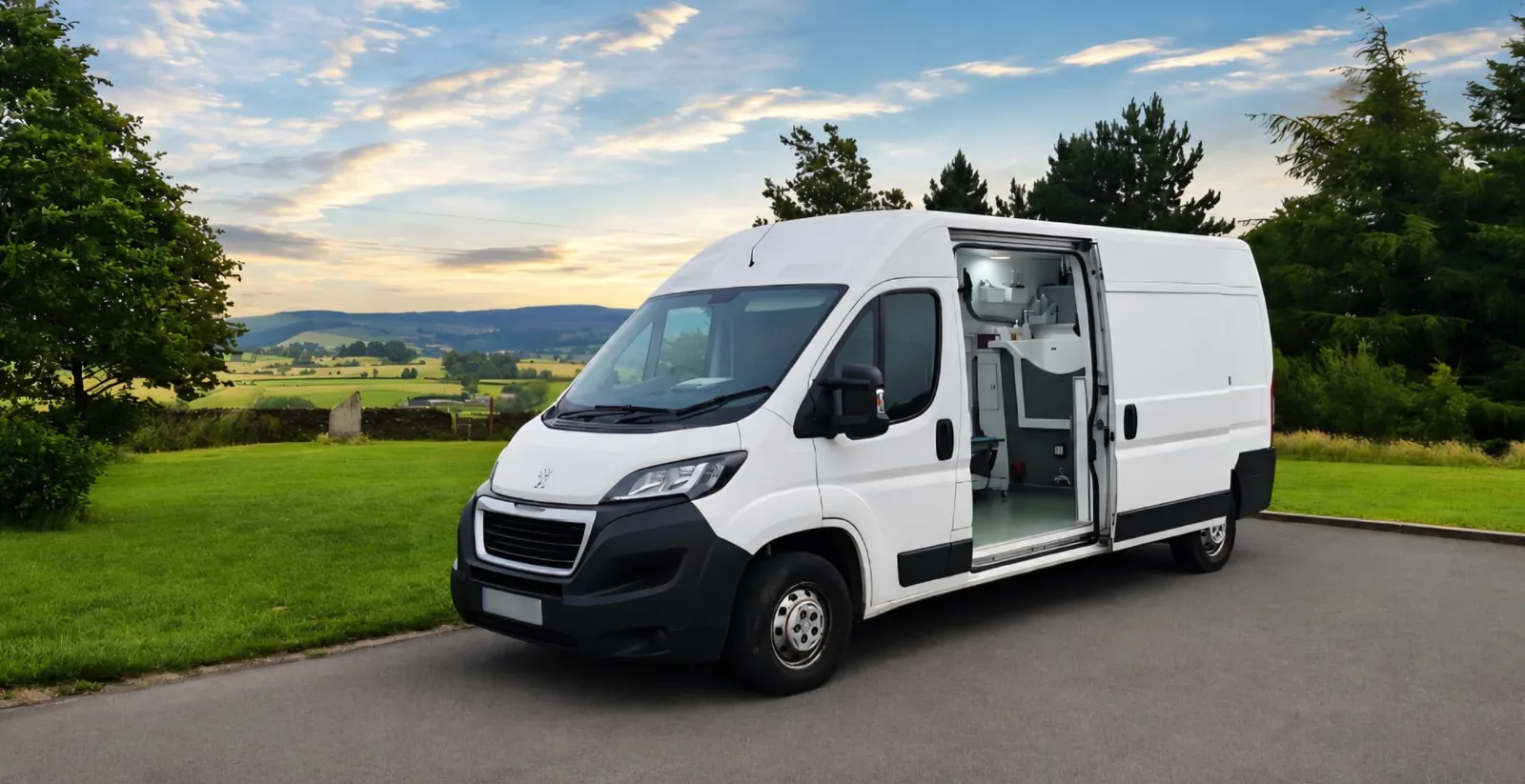 The Coyote Comb Club grooming van, side door open, parked overlooking the valley